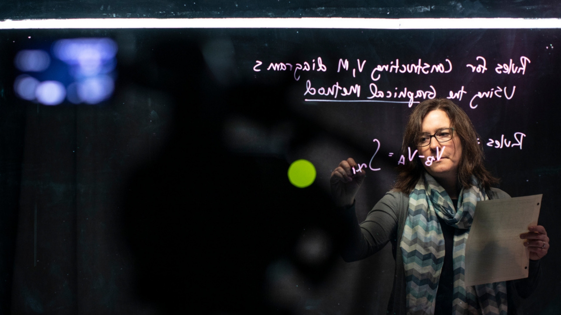 Professor Acton writes out math equations