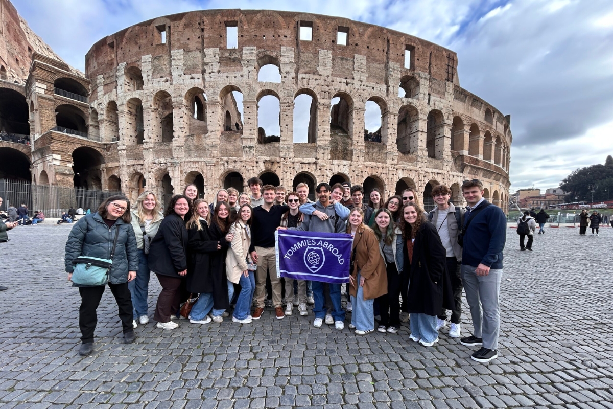 a group of engineering students pose in front of the Roman colosseum 