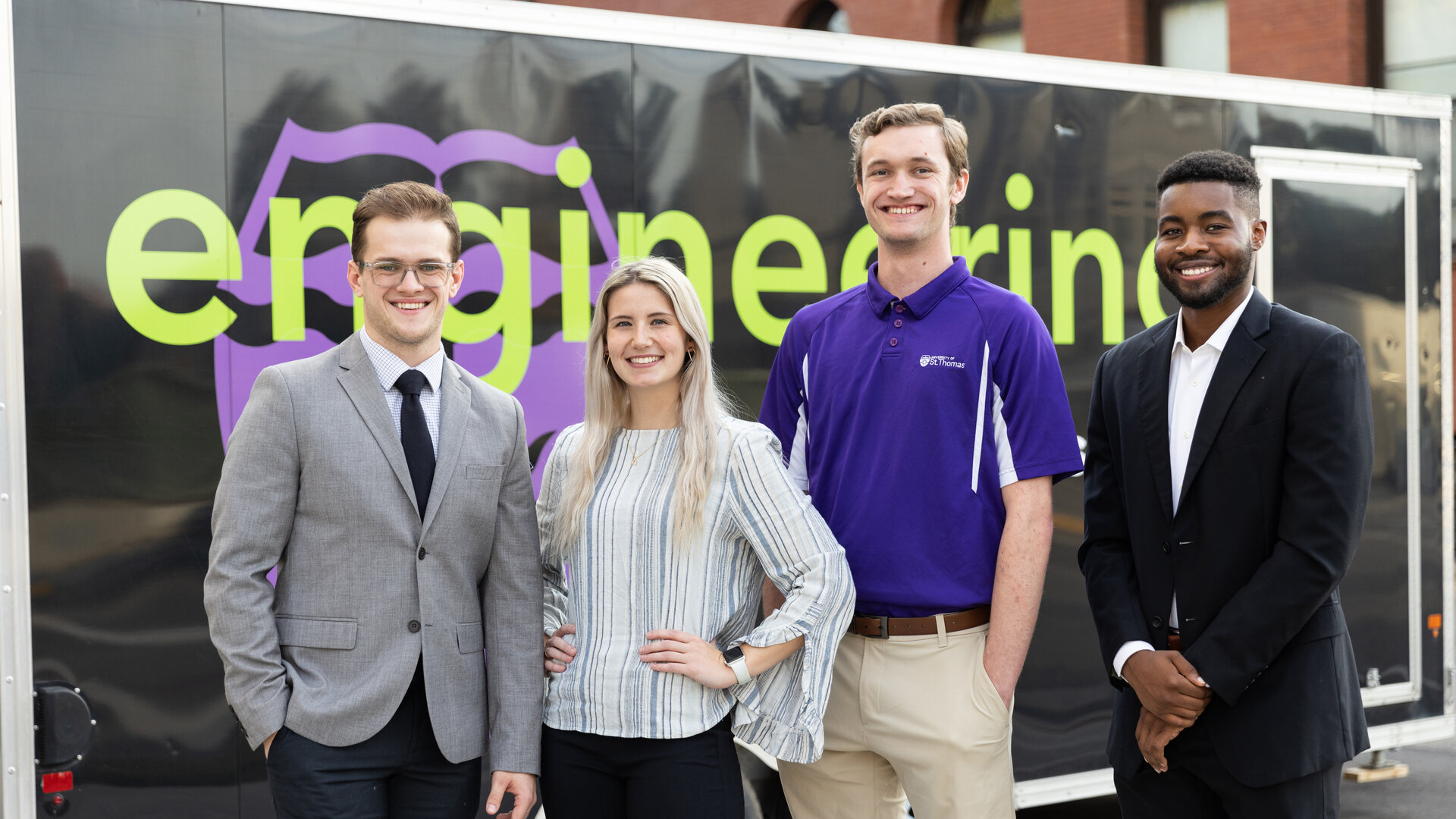 Senior engineering students pose in front of Engineering's trailer.