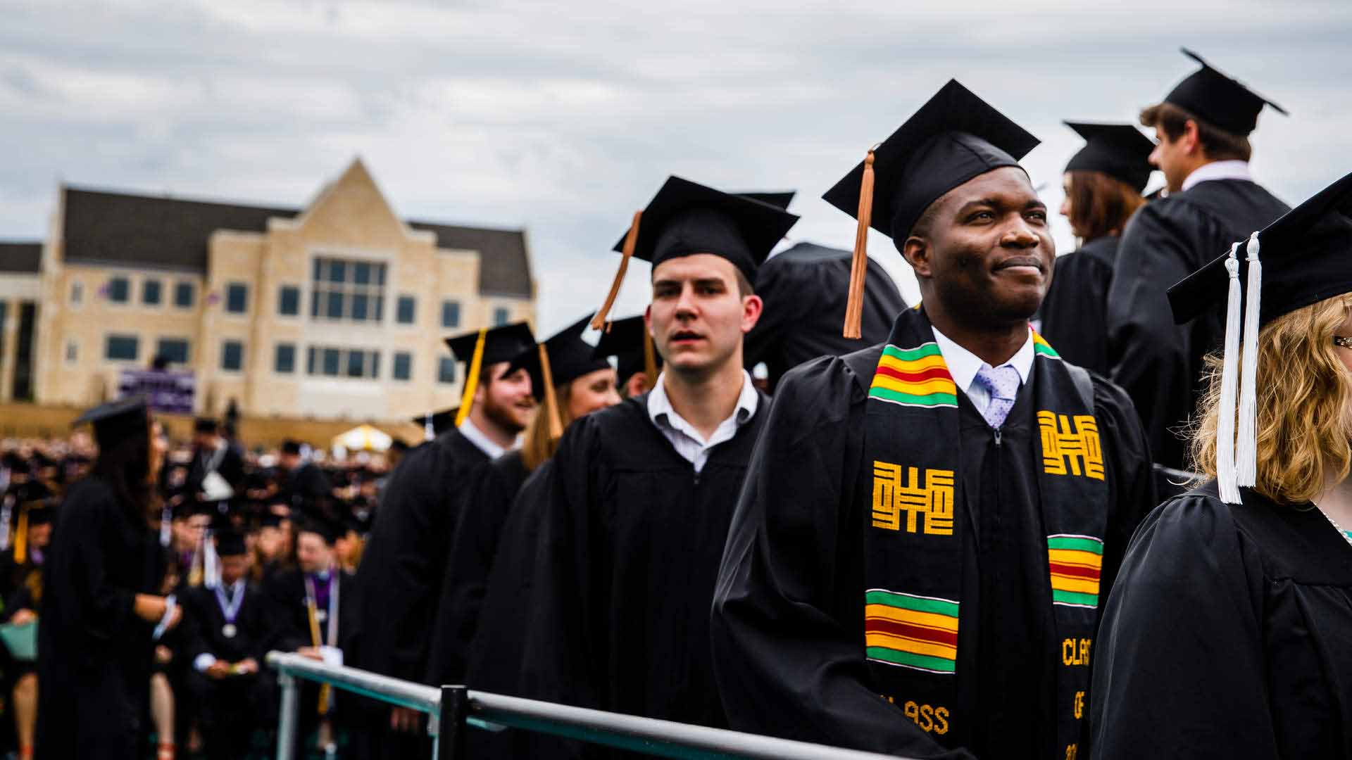Graduate student stands in line during graduation 