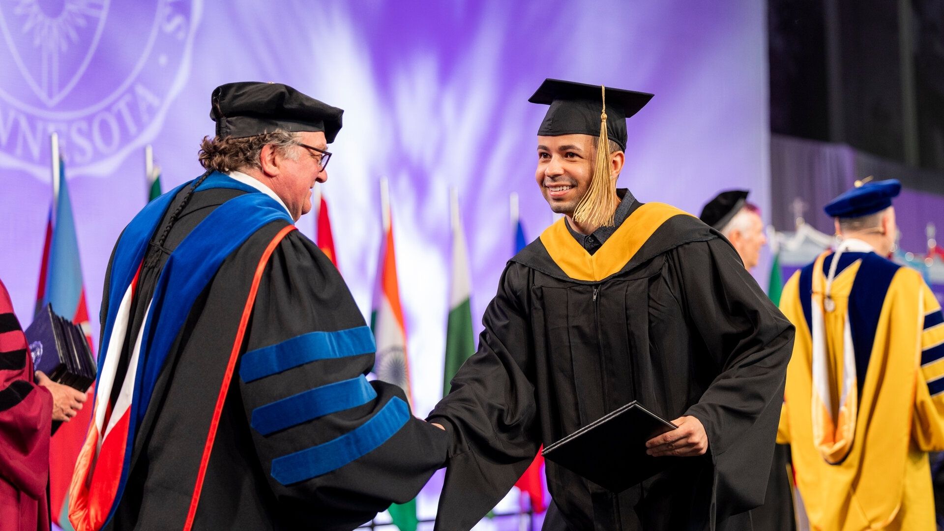 Graduate student shakes hand with the Engineering Dean during graduation 