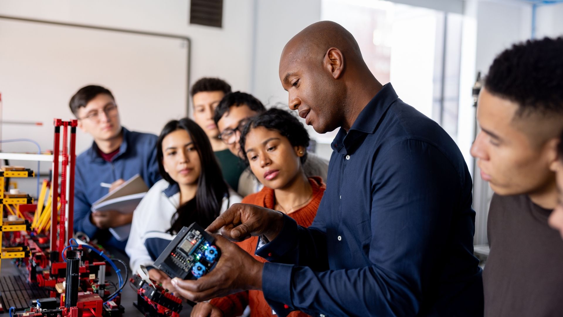 Group of teachers look at an engineering equipment demonstration.