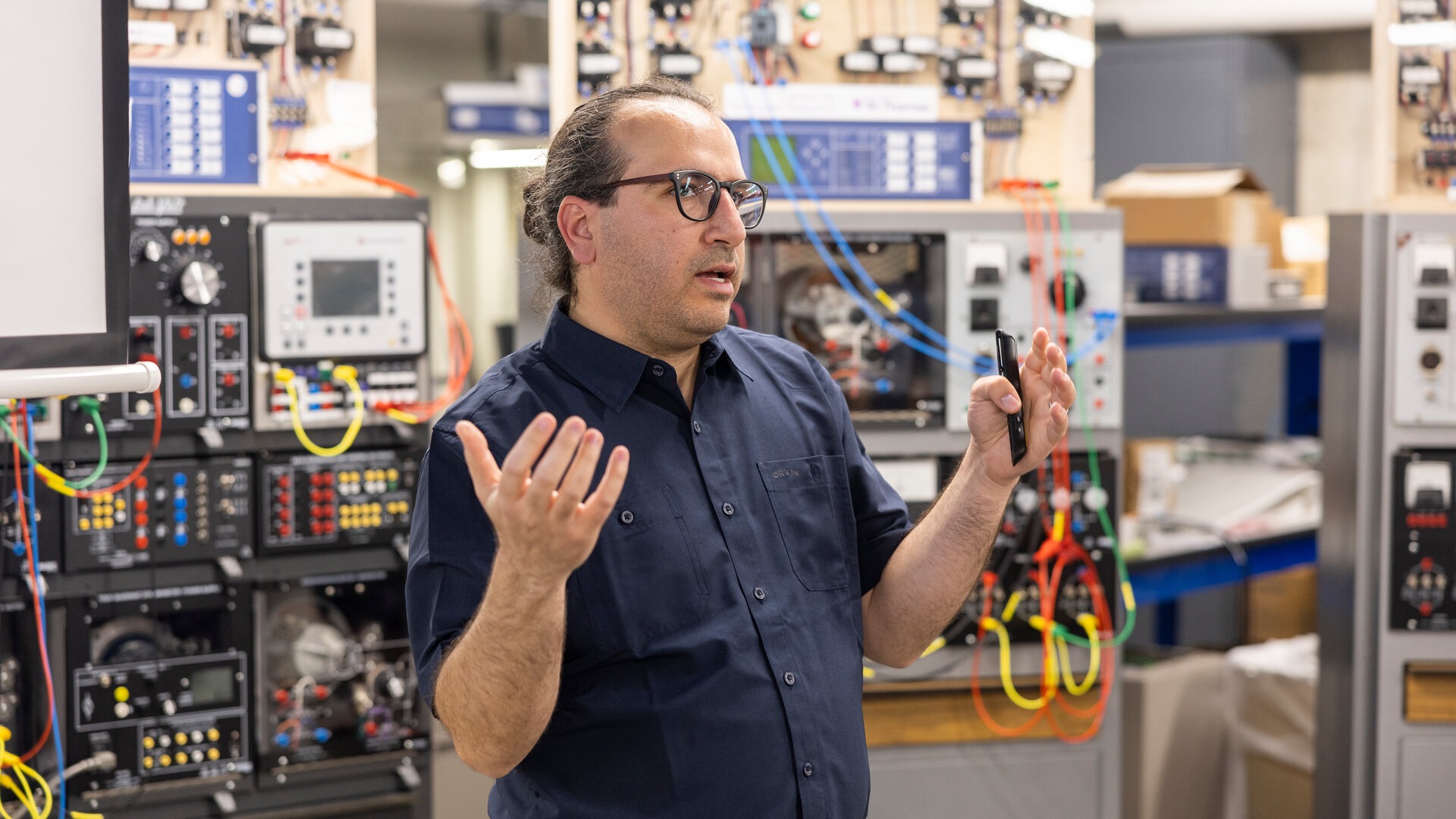 Dr. Mahmoud Kabalan stands in front of microgrid equipment.