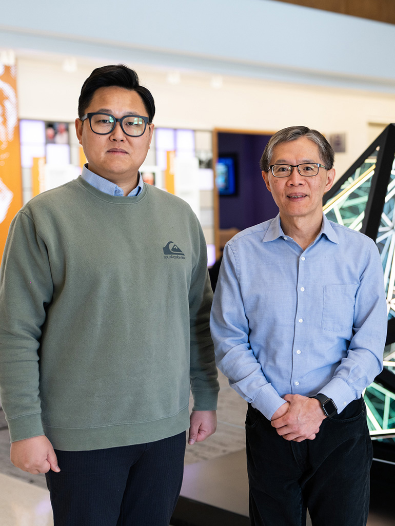 Graduate student and faculty stand in the Schoenecker Center atrium on the St. Thomas St. Paul MN campus.