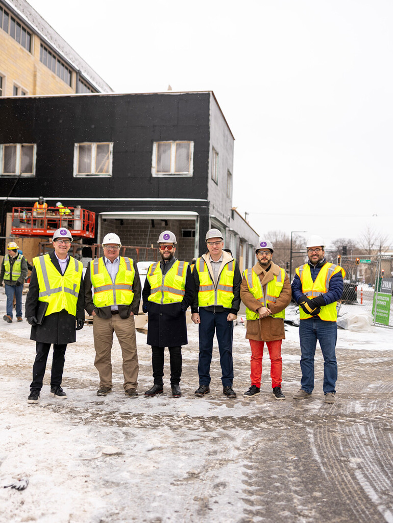 St. Thomas faculty and industry partners stand in front of new microgrid expansion construction.