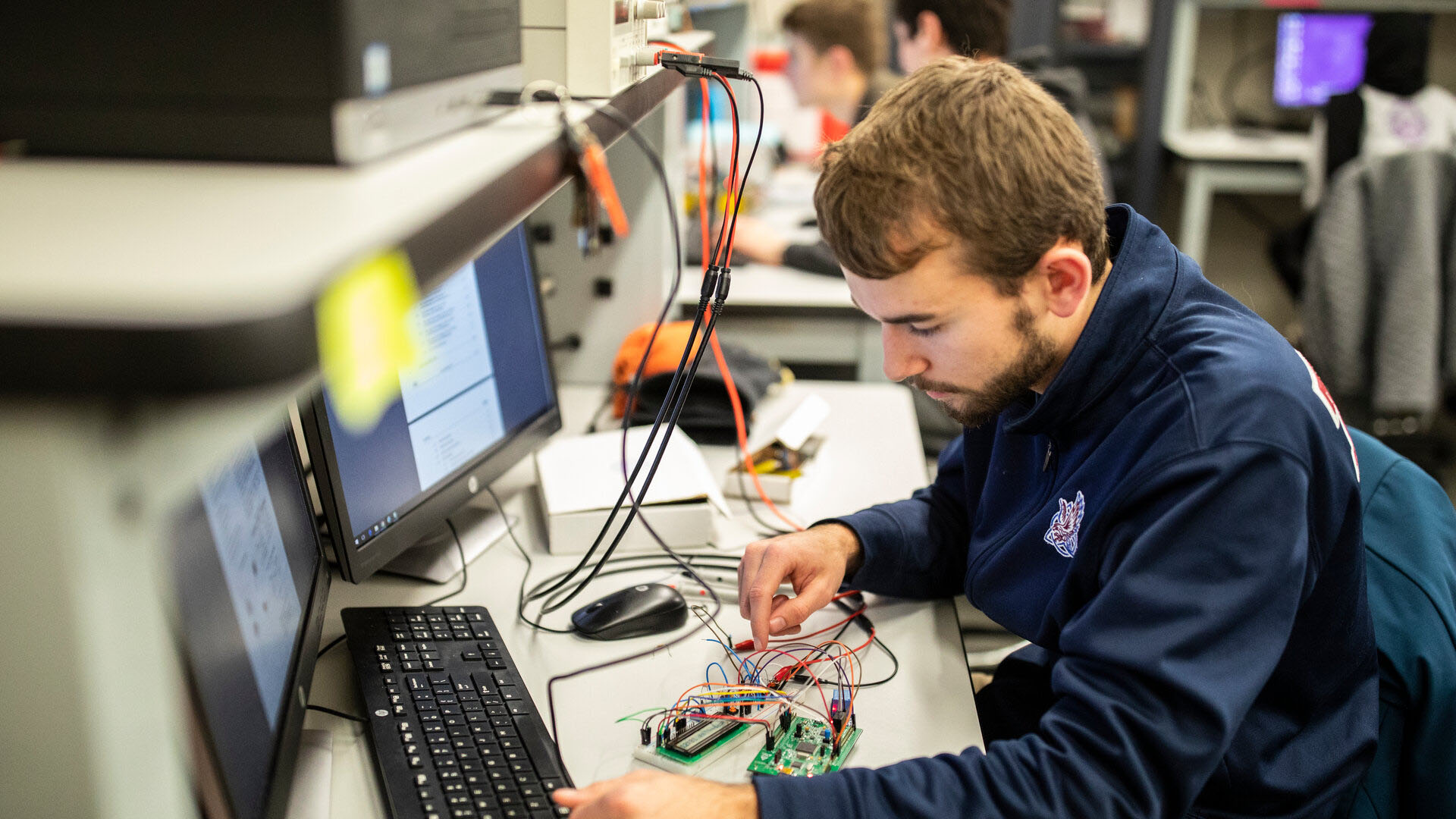 Engineering student works on wiring a circuit.