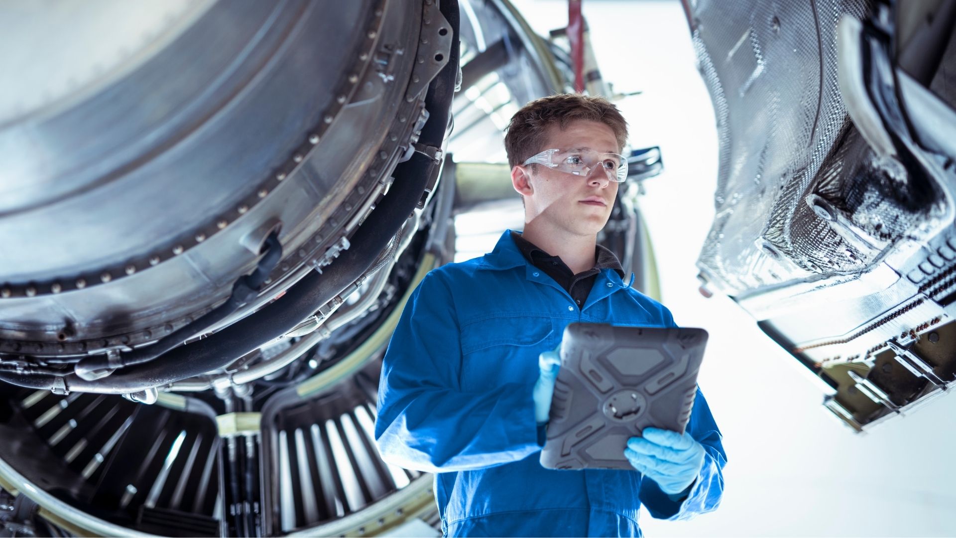 quality engineer holds a tablet near an engine turbine