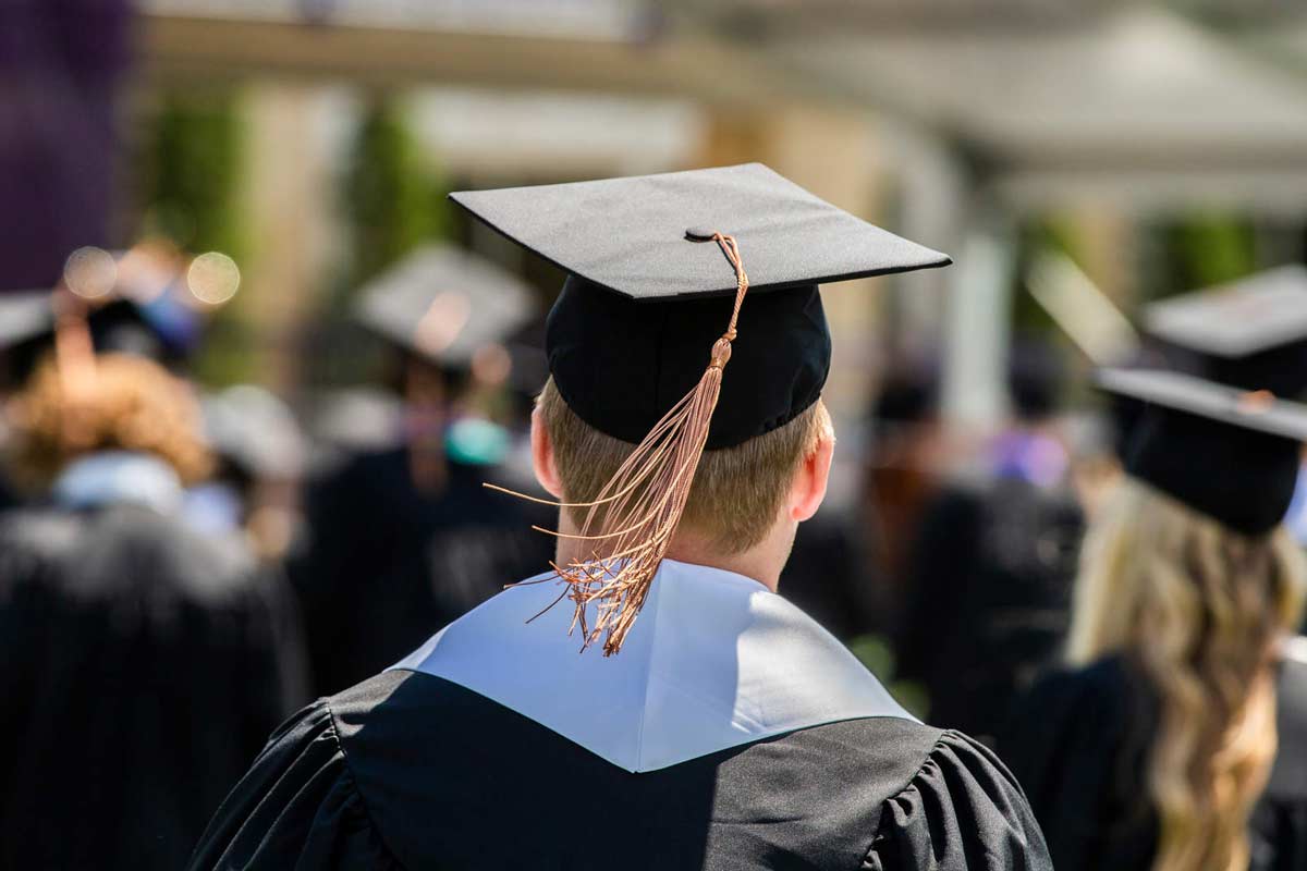 Back of individual wearing a cap and gown.