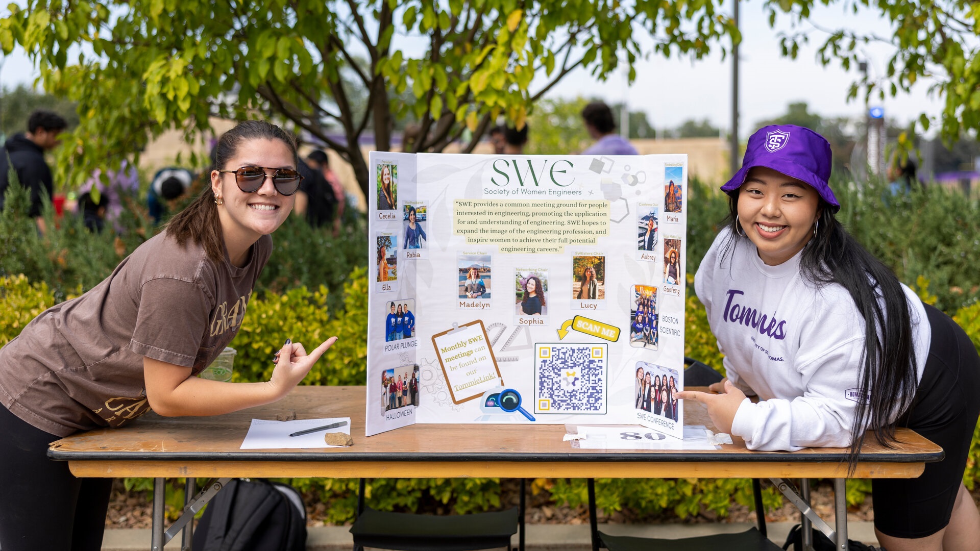 St. Thomas Engineering students pose next to a poster promoting the Society of Women Engineers.