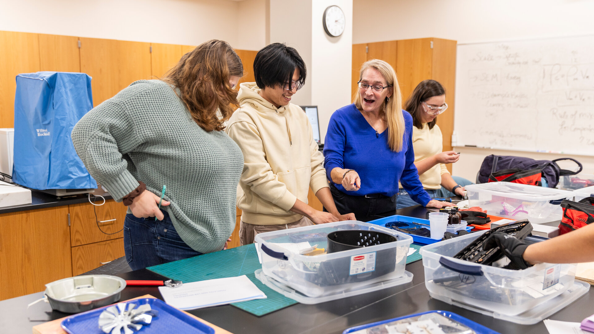 Engineering students participate in an activity while faculty assists them.