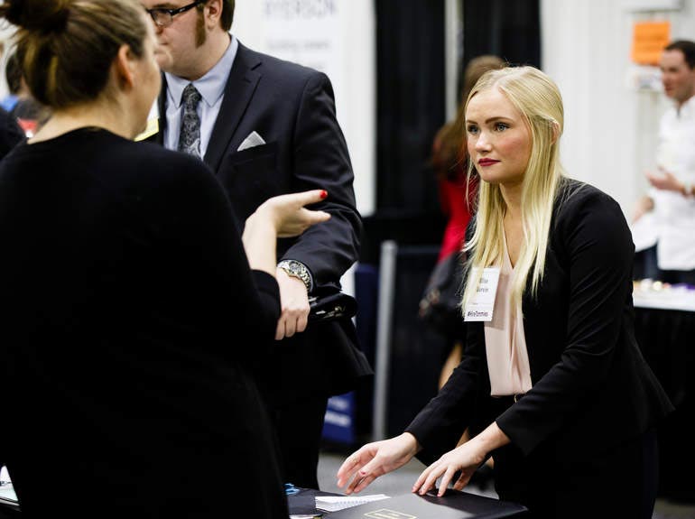 Student talks with potential employers at an internship fair