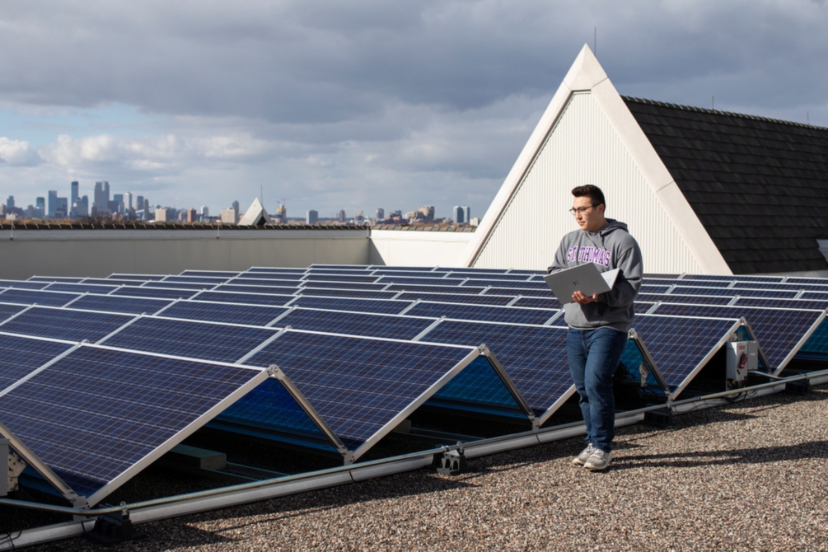 computer engineering student walks among the solar panels