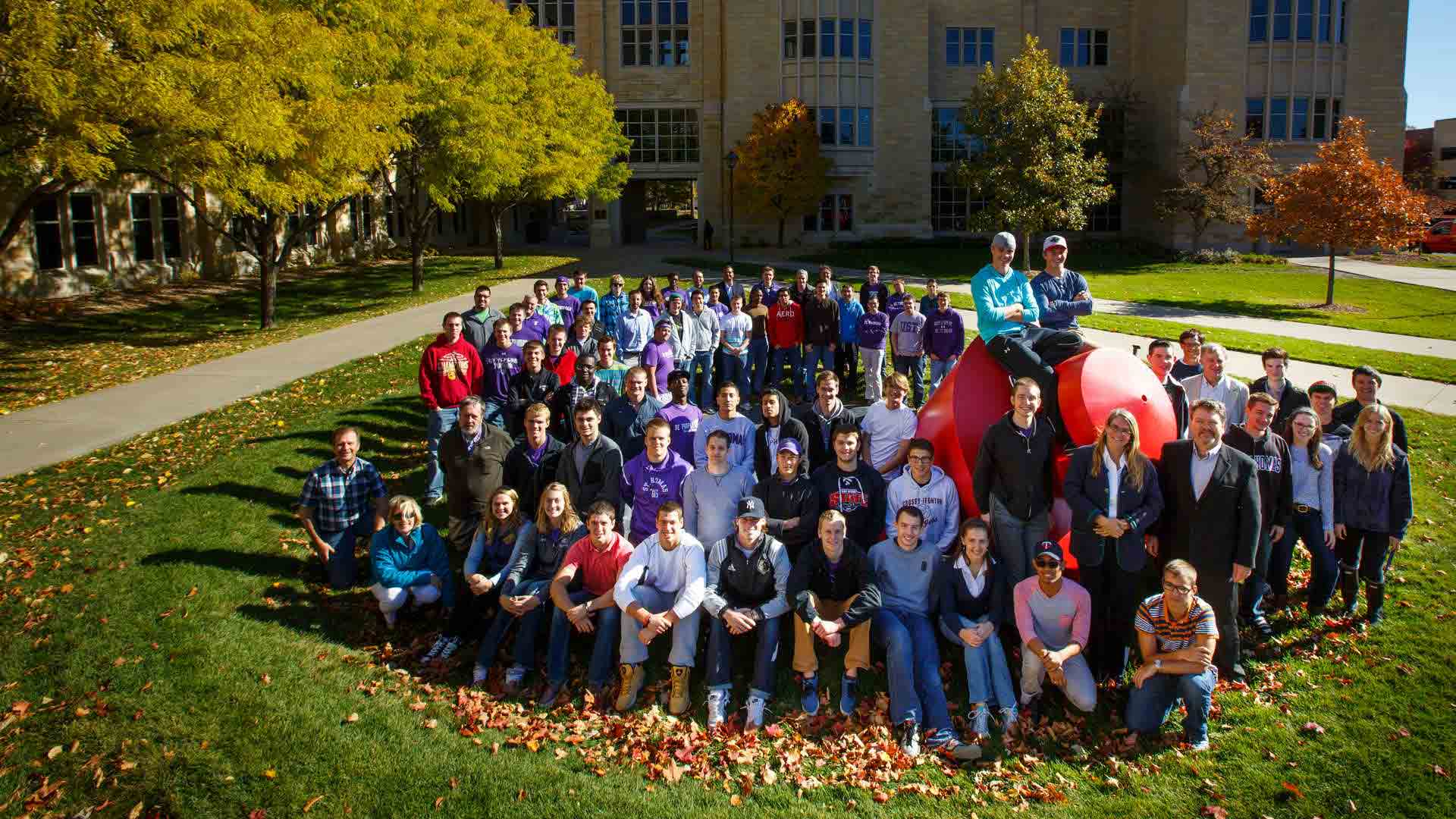 School of Engineering students stand next to "The Plunge" sculpture.