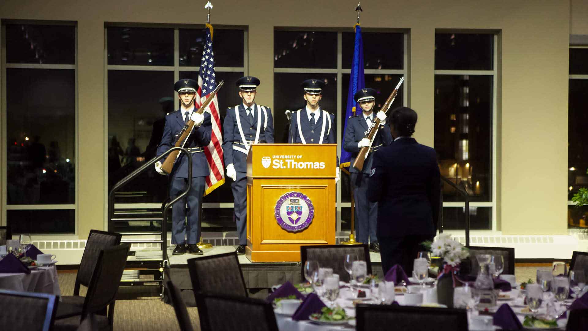 Veterans stand behind a podium at the veterans ball