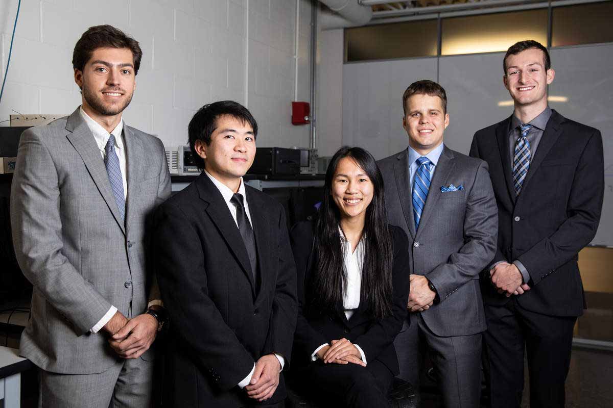 A group of engineering students pose for a senior design photo