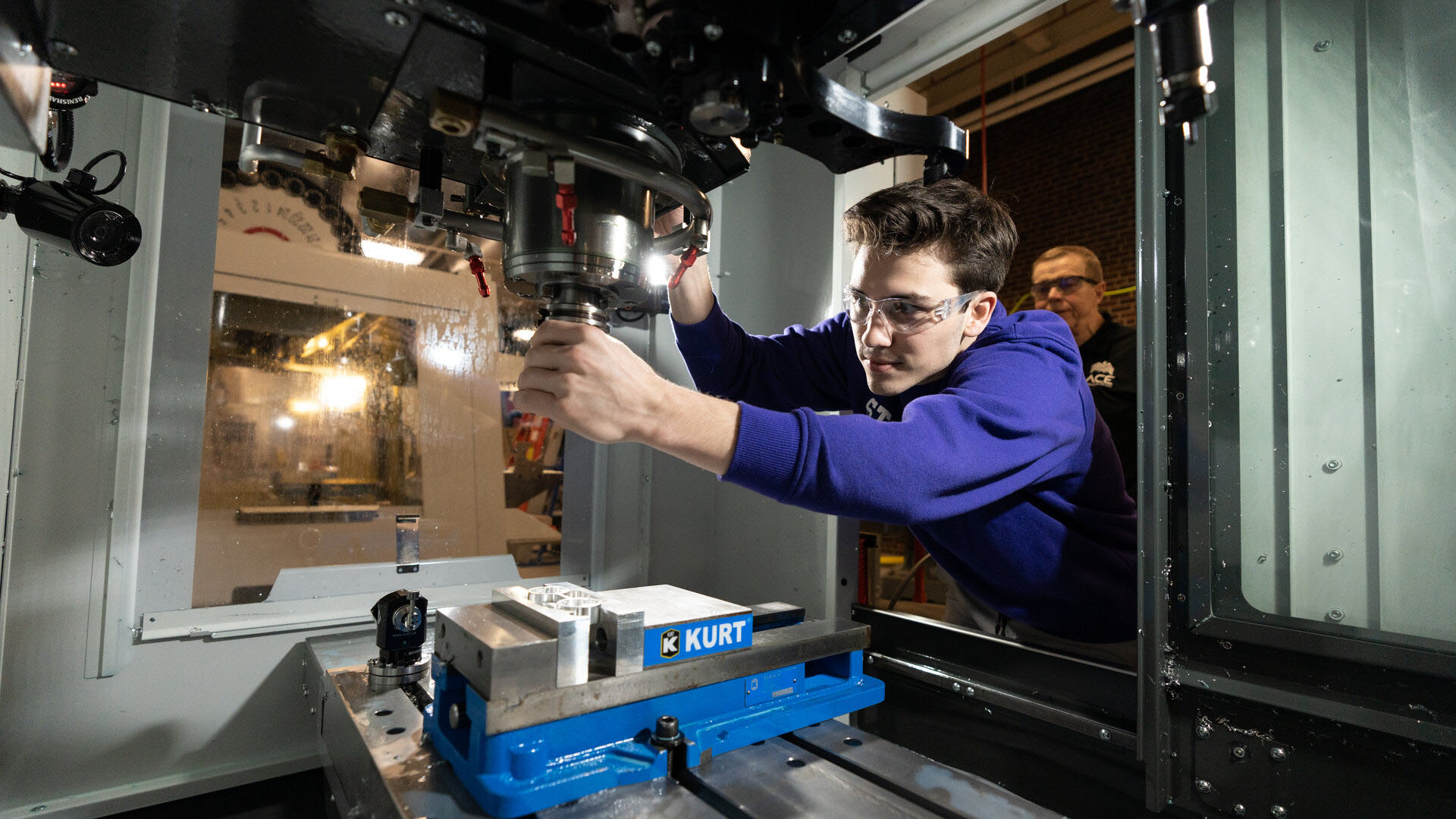 Engineering student manipulates CNC machinery