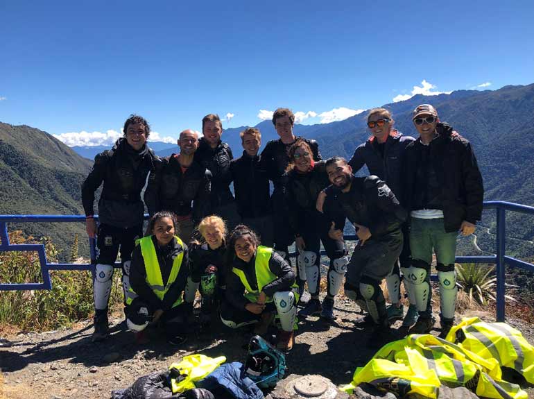 Group of students stand together on a mountain.