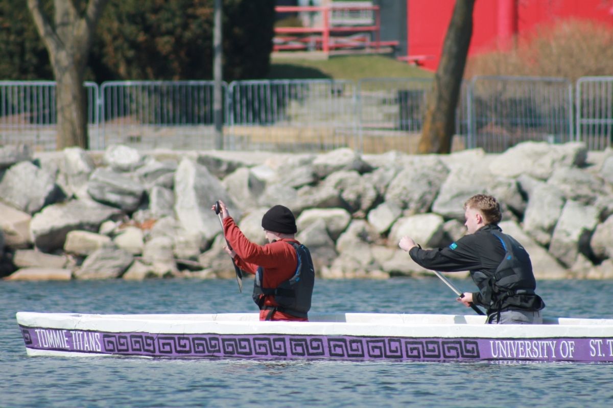 Two St. Thomas civil engineering students row concrete canoe in competition.