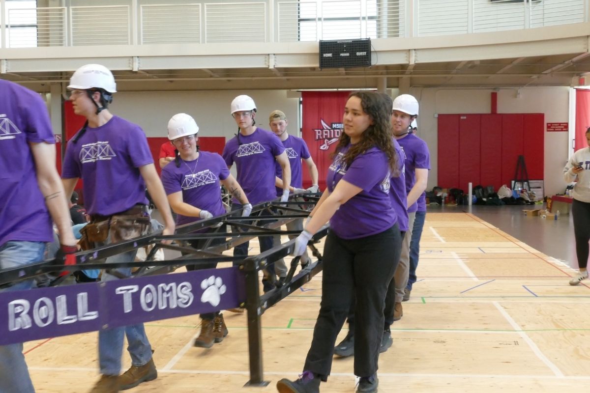 Civil engineering students work on steel bridge project.