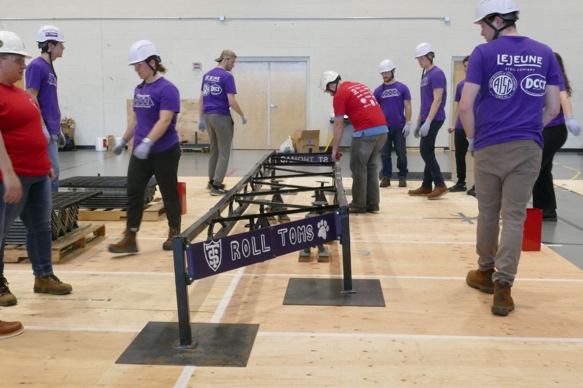 Civil engineering students work on steel bridge project.