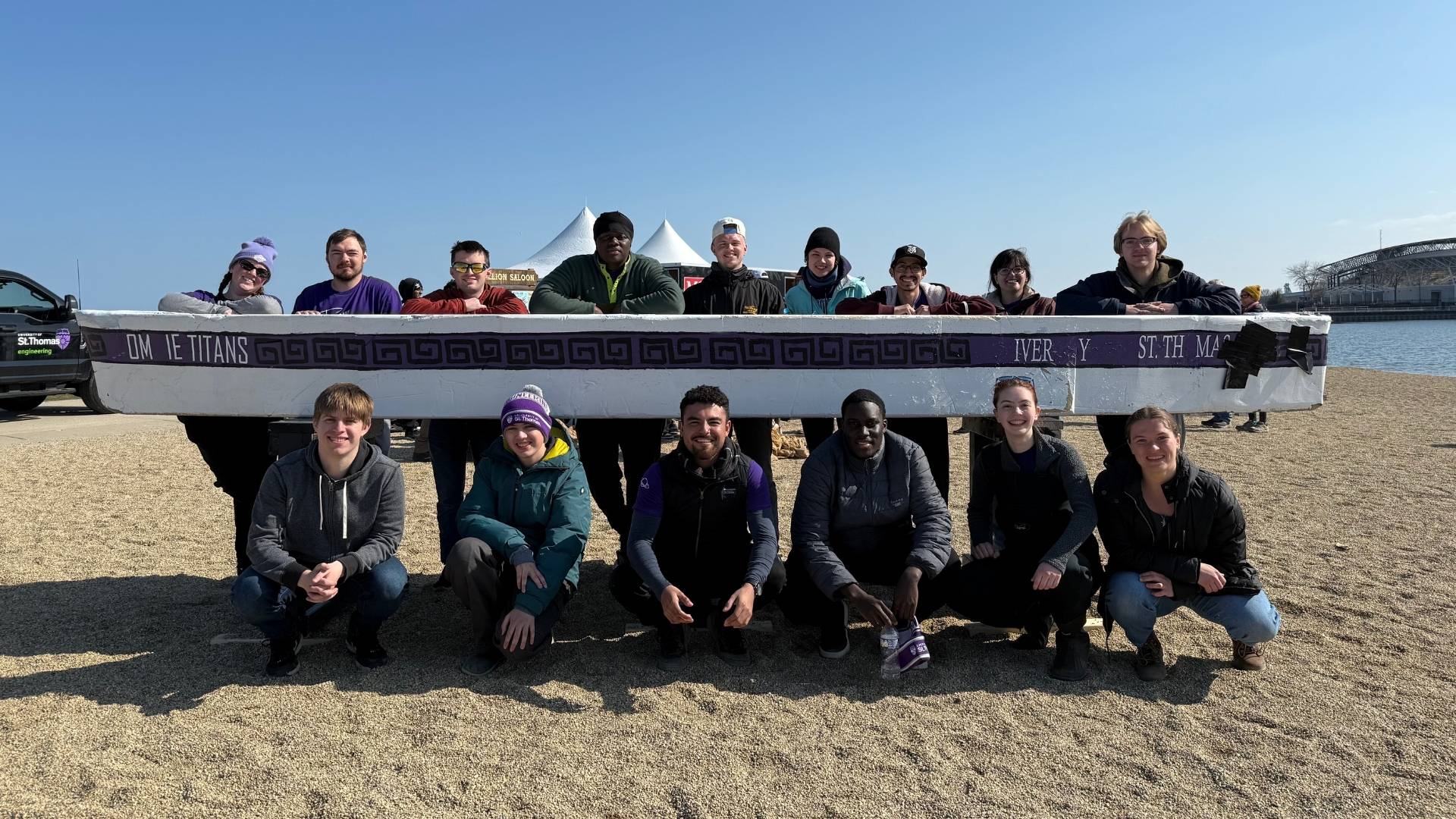 St. Thomas civil engineering students pose for a photo next to their team's concrete canoe.